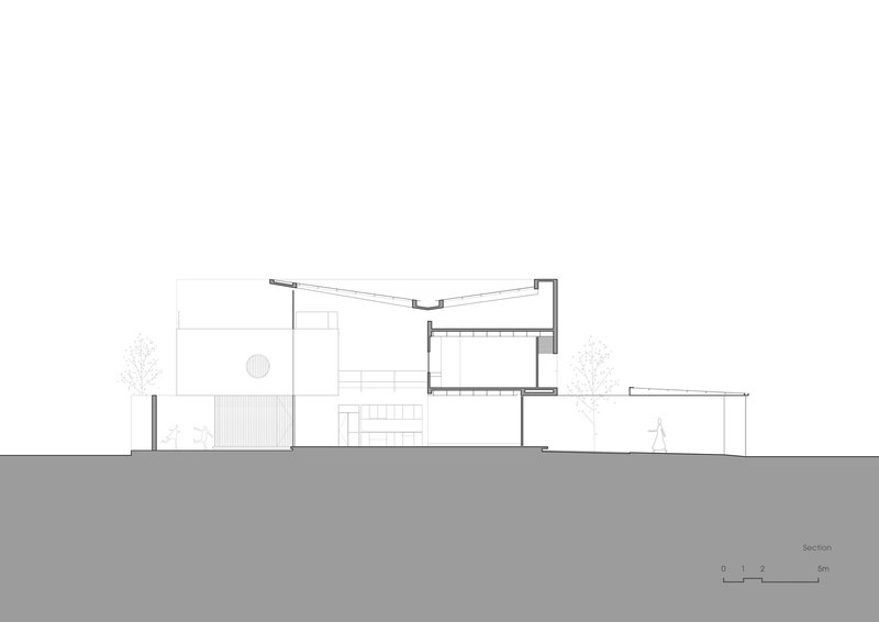 Section drawing showing a two-level residence with sloped roof and interior stairs flanked by trees