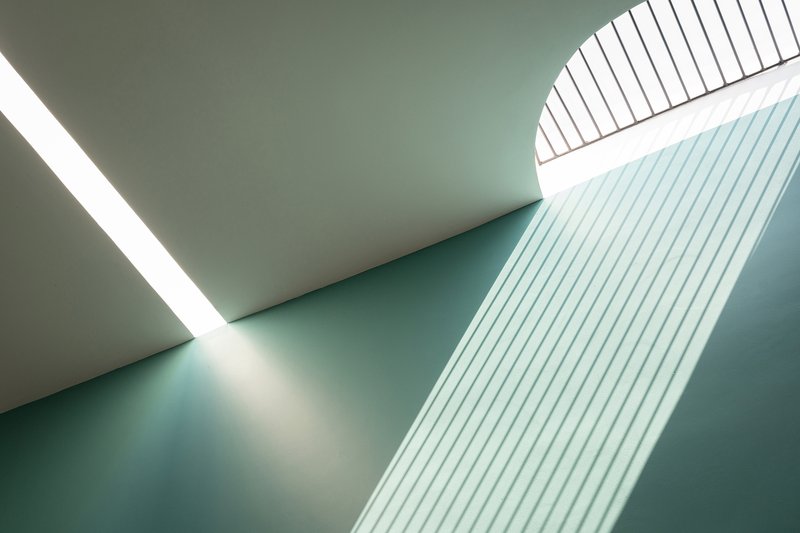 Skylight view showing sloped ceiling planes and vertical slatted screen in pale blue