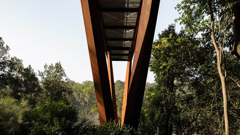 Underside view of the cantilevered walkway structure showing timber beams and steel mesh decking