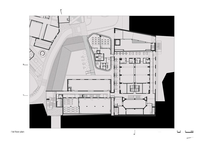 First floor plan showing courtyard, auditorium block, and adjacent structures with landscaped surroundings