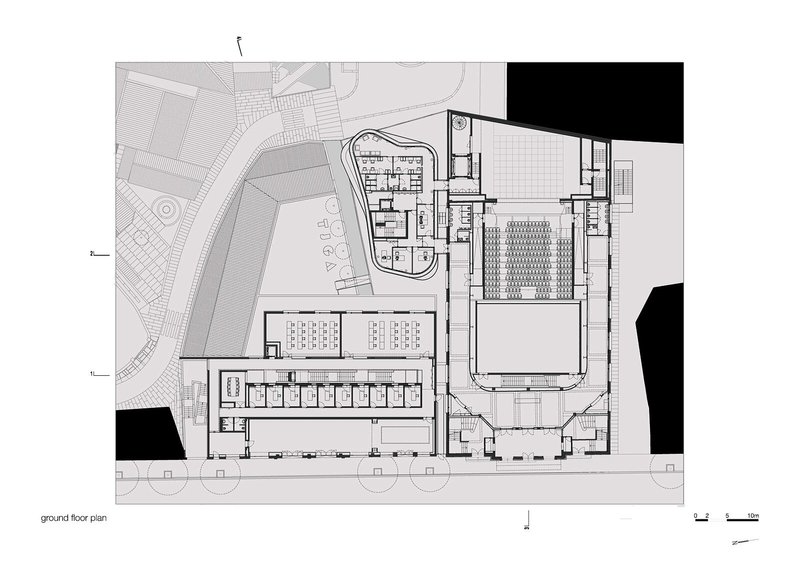 Ground floor plan drawing revealing large performance hall, seating rows, and circulation zones with adjacent courtyard