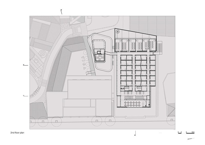 Second floor plan drawing displaying grid of rooms along one wing and smaller pavilion with curved courtyard