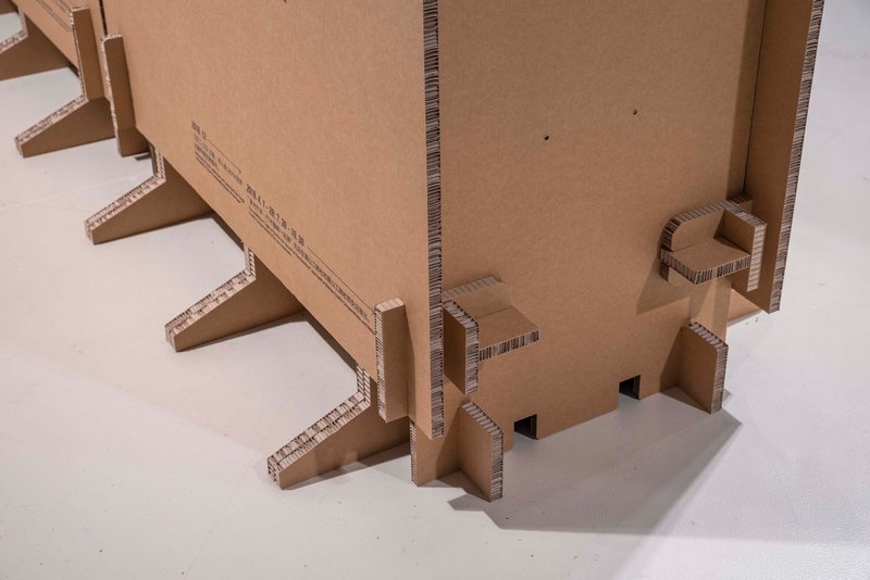 Close-up of corrugated cardboard structural supports and joinery at the model base
