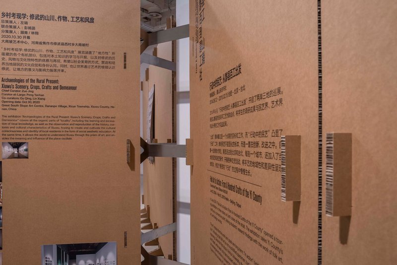 Cardboard architectural model with text panels and interior openings revealing layered spaces