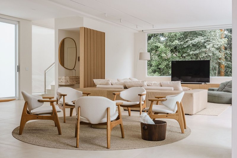 Open living area with timber-slatted screen dividing dining and lounge zones under track lighting