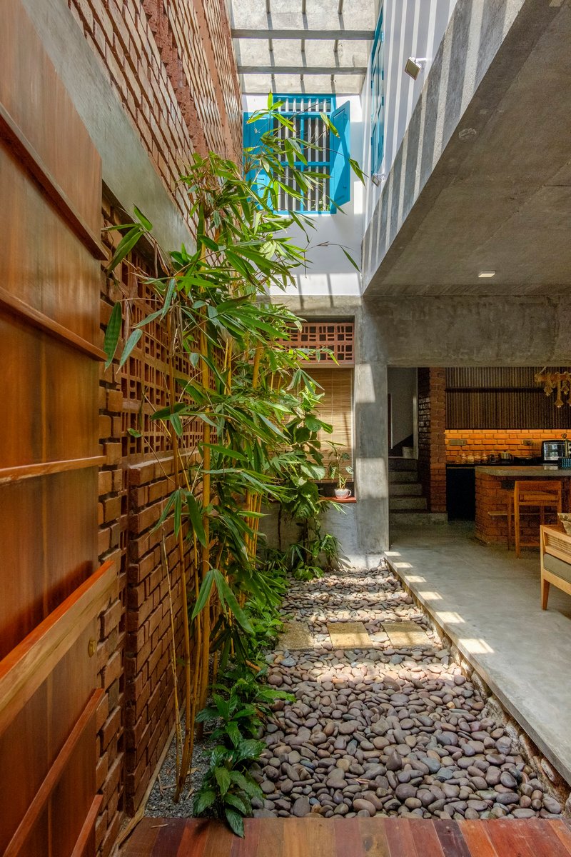 Interior courtyard with bamboo planting, pebble ground, and glazed skylight above