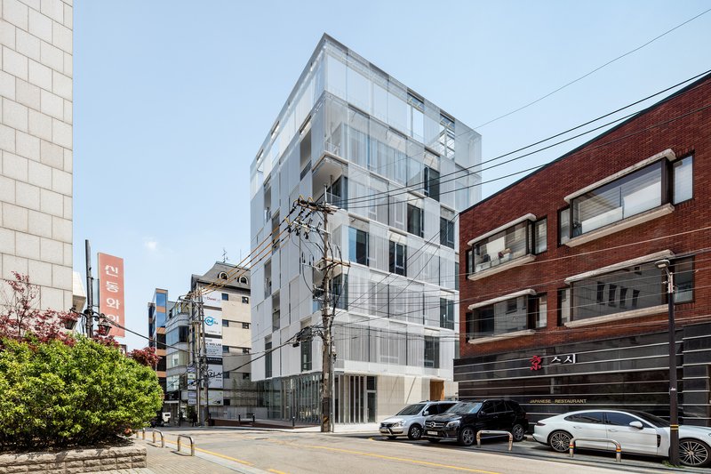 White paneled facade with vertical ribs and recessed windows under a clear sky