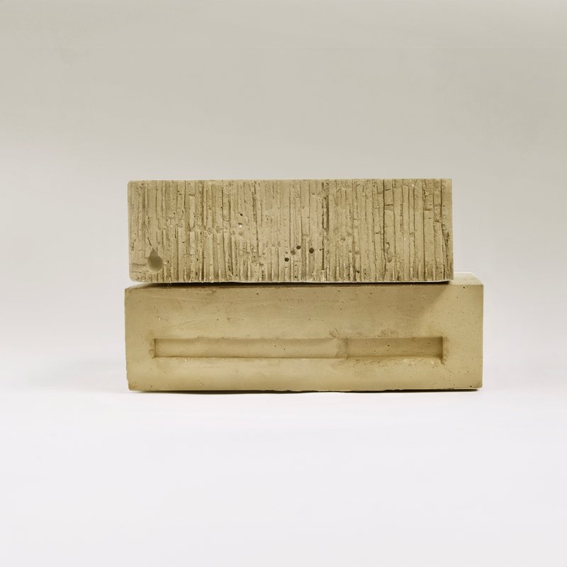 Side view of plaster model revealing board-formed facade and smooth base under neutral light