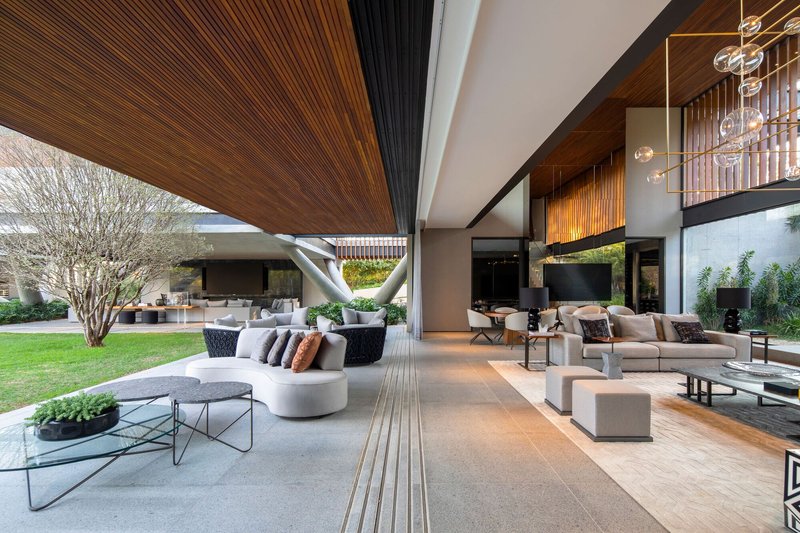 Open living space with timber slatted ceiling extending from interior to covered outdoor terrace