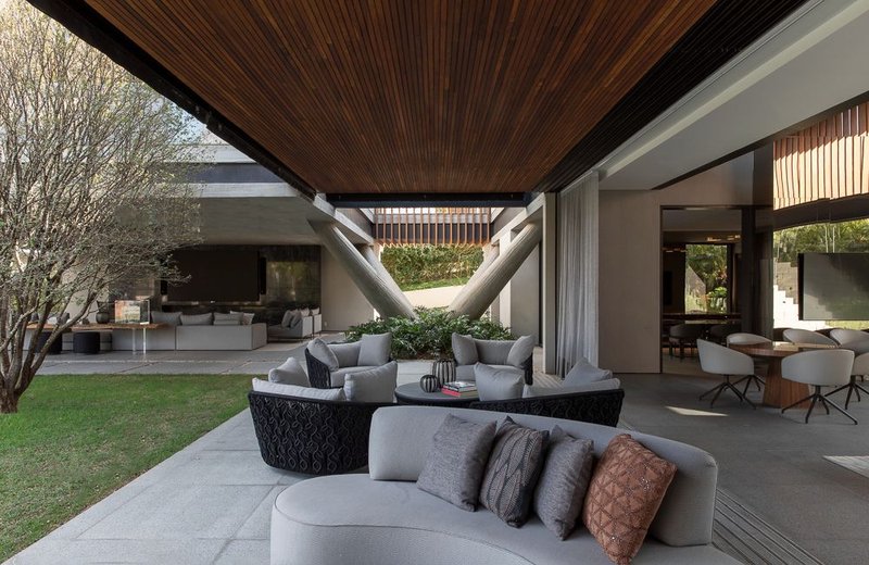 Covered terrace with timber ceiling and curved seating opening to interior living spaces and garden