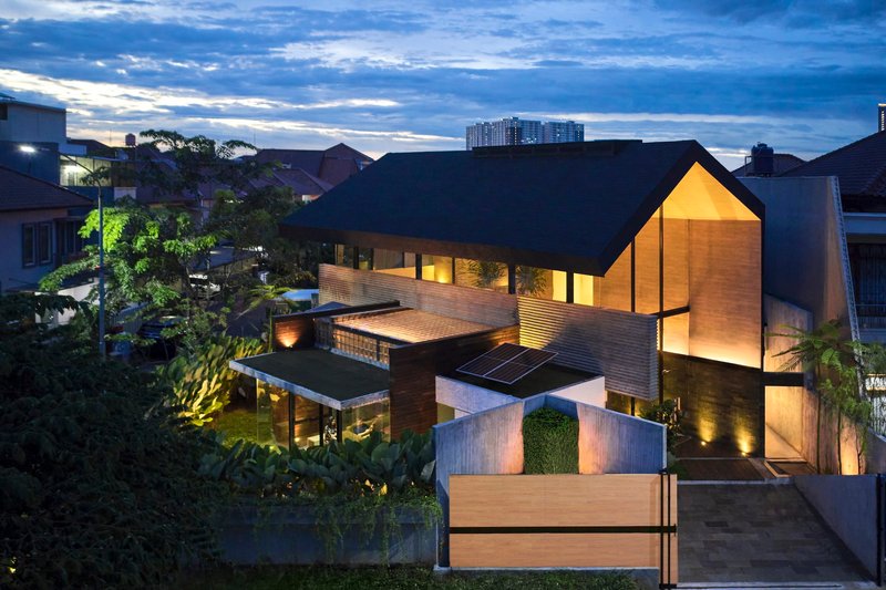 Aerial view of the split-pitched roof with solar panels and illuminated courtyard at dusk