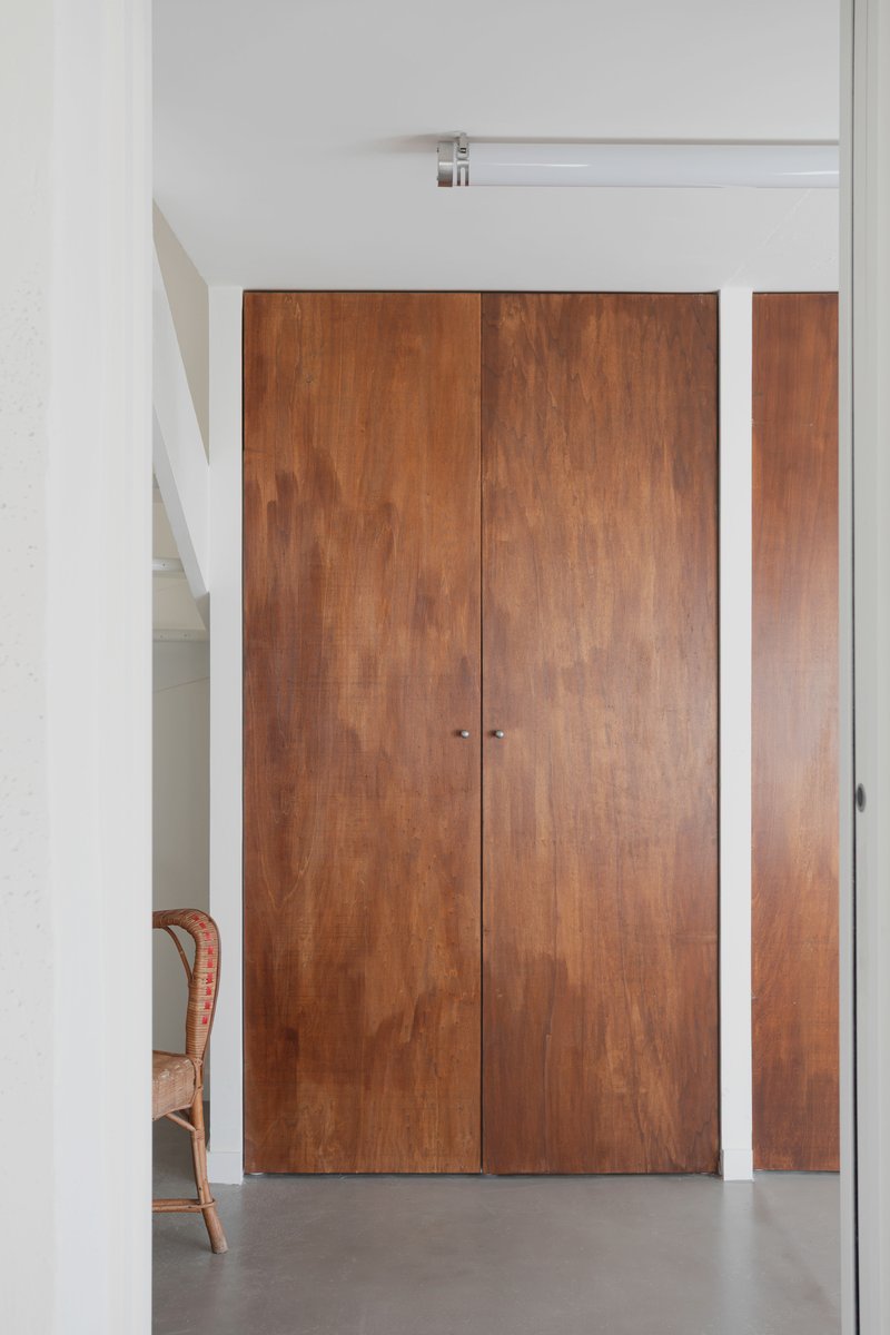 Timber double doors with white frame and sidelight panel opening to a polished concrete floor