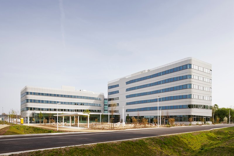 Street view of two office buildings with horizontal banding of white cladding and blue-tinted glazing