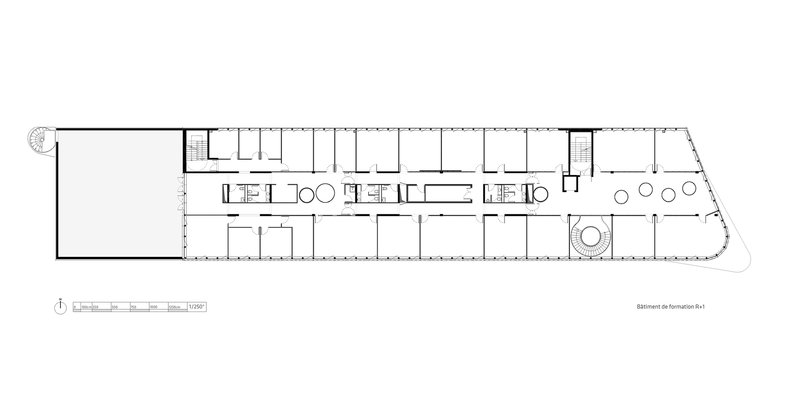 Floor plan drawing displaying a long linear bar with repeating rooms and a circular central element