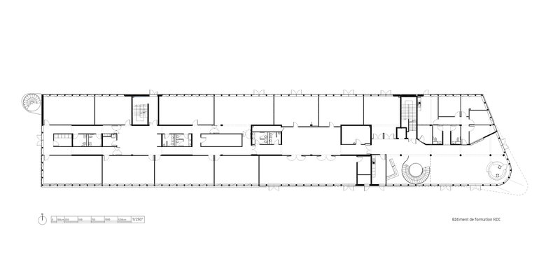 Floor plan drawing depicting enclosed rooms along a linear corridor with circular elements at one end