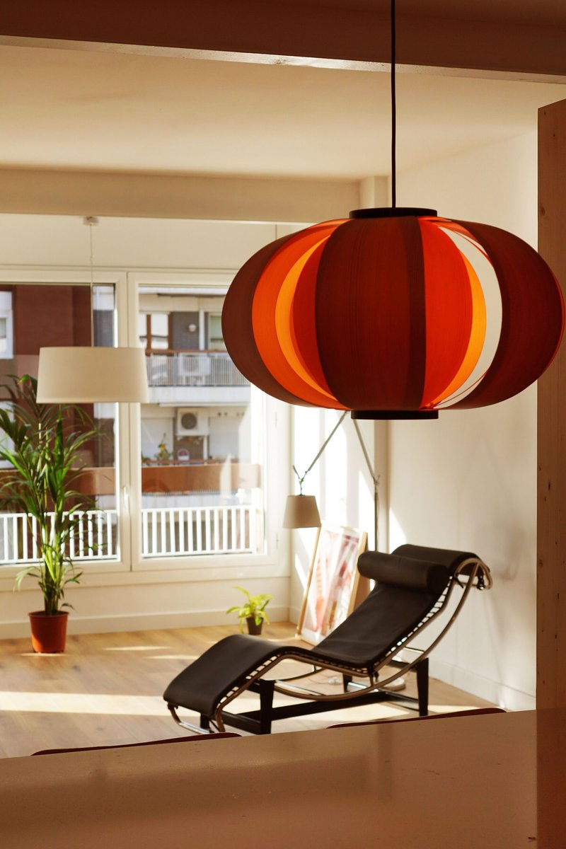 Close-up of a red and orange segmented pendant lamp hanging in a daylit interior