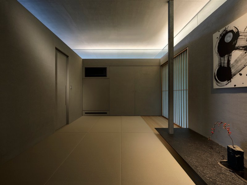 Tatami-floored room with concealed cove lighting and translucent screen illuminated at dusk