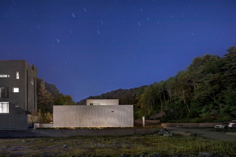 Long exposure of the ribbed concrete facade under a deep blue sky with star trails