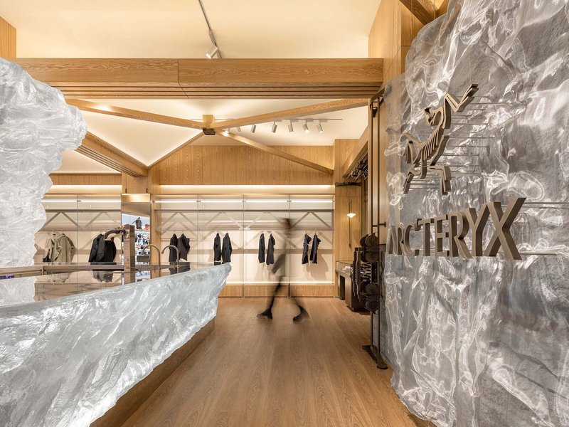 White textured wall panel with branded signage next to a retail display under timber trusses