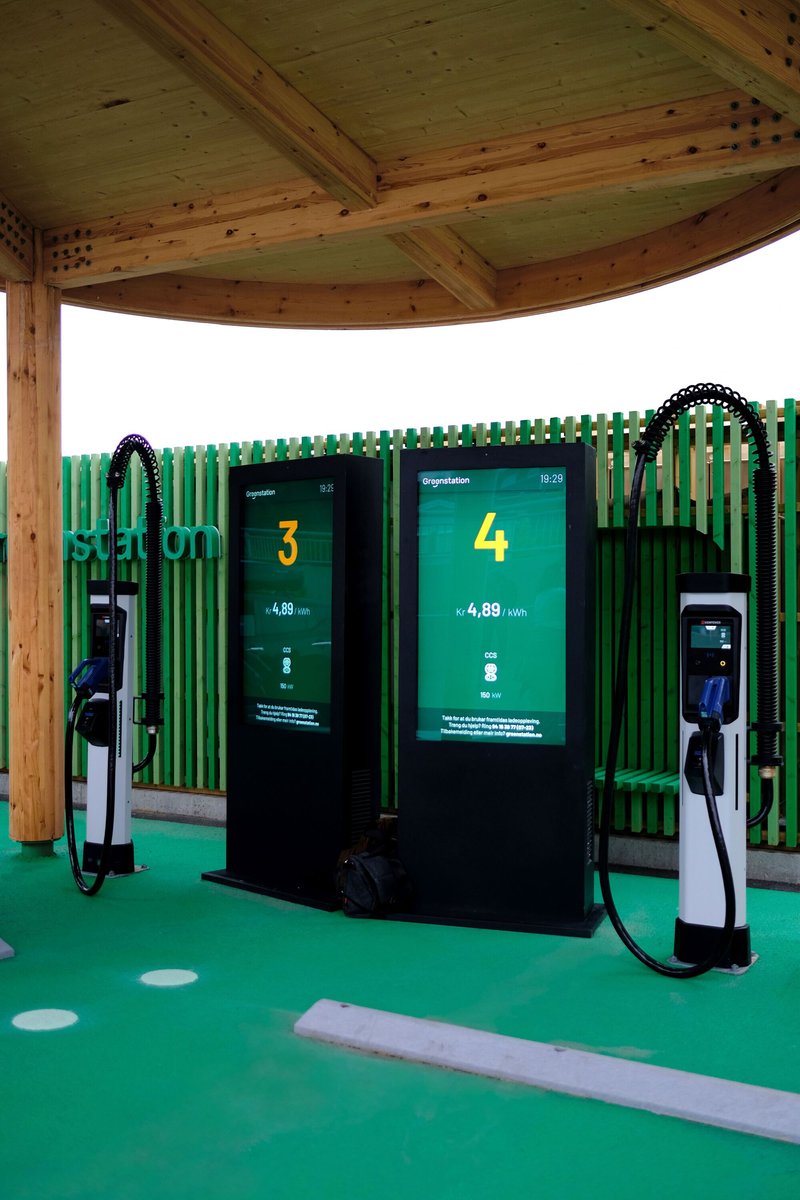 Electric vehicle charging stations beneath the timber canopy with green metal screening and rubber flooring