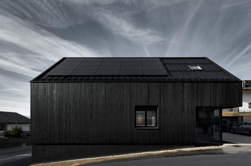 Solar panel array integrated into the pitched roof with photovoltaic modules and a single skylight opening