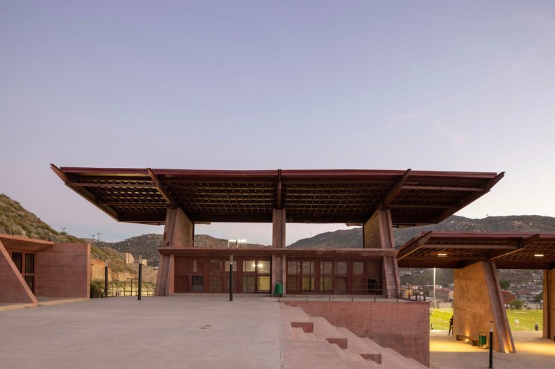 Elevated plaza with cantilevered roof plane and glazed enclosure at the center pavilion