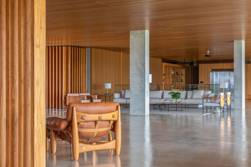Polished concrete floor reflecting light beneath timber screen and concrete columns