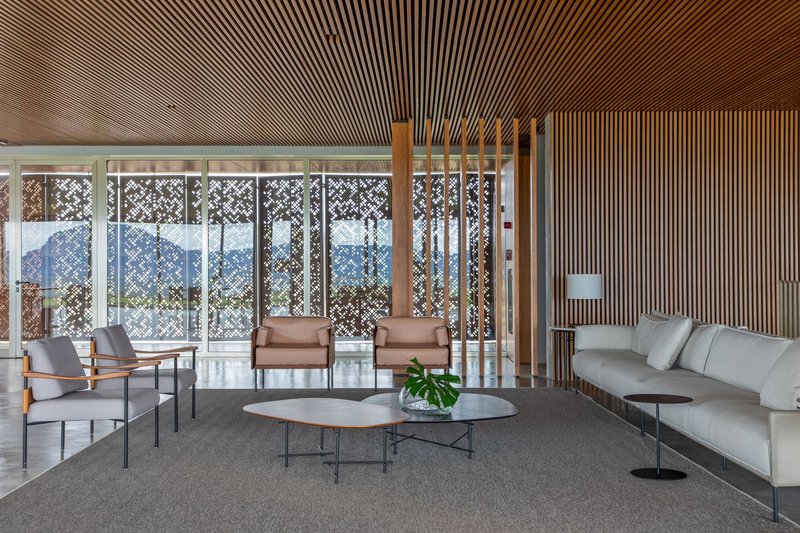 Lobby with slatted timber ceiling and perforated metal screens overlooking the vineyard landscape