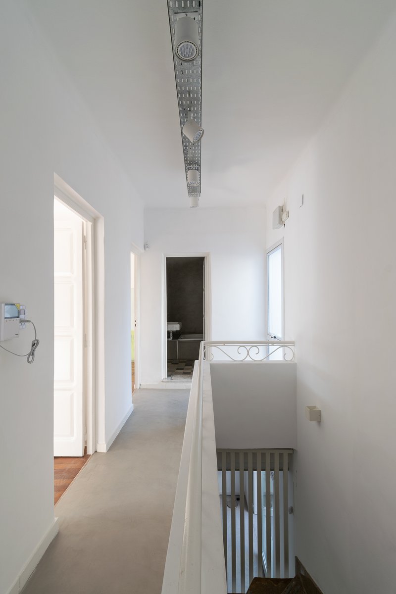 Upper floor hallway with polished concrete flooring and exposed metal beam along the white ceiling