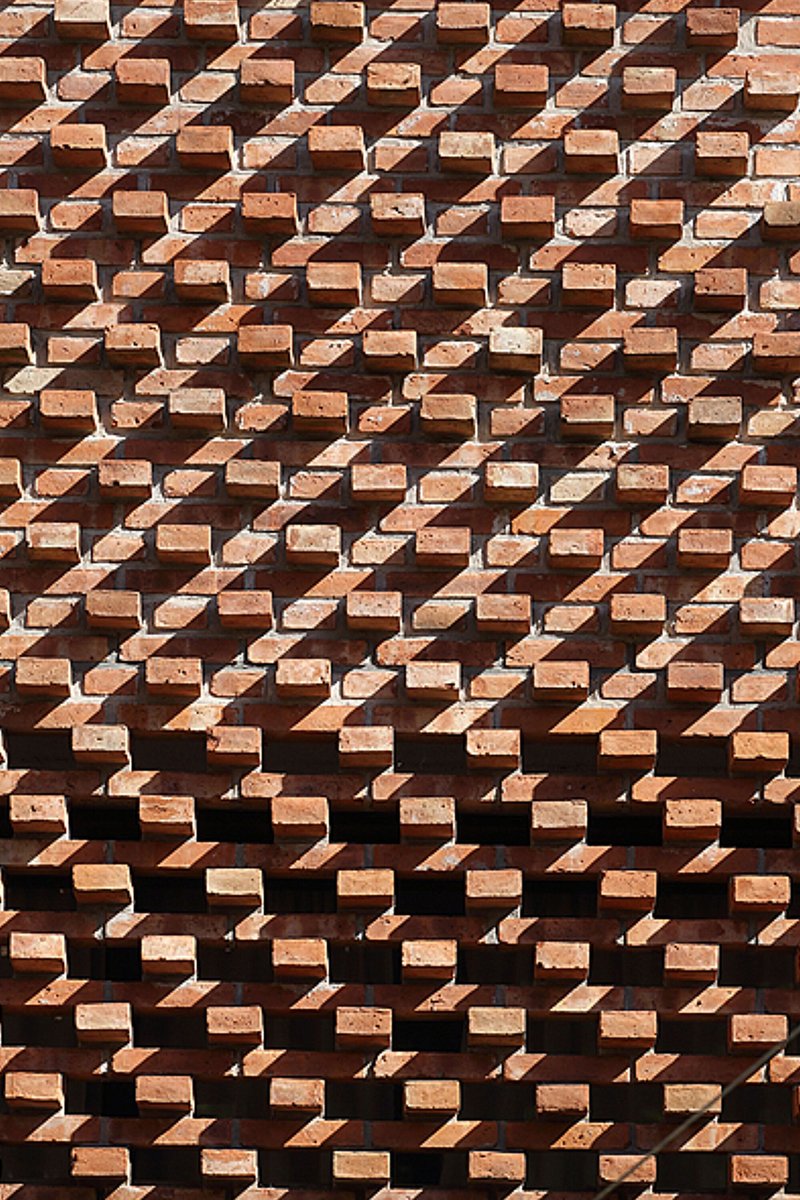 Detail of the projecting brick coursing in afternoon sunlight creating geometric relief