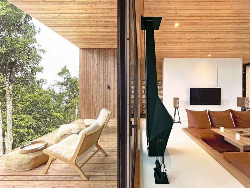 Sliding glass door threshold between timber deck and bedroom with white feature wall