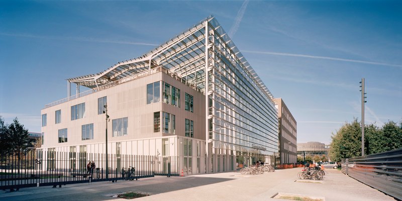 Street view of the metal panel facade with glass louver roof structure visible above