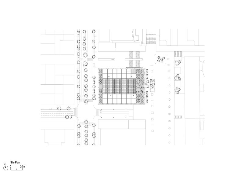 Site plan drawing showing a rectangular building footprint surrounded by landscaped areas and street trees