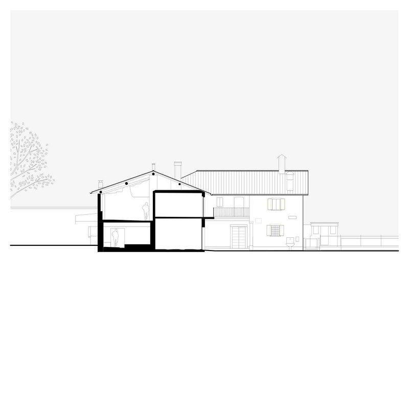 Section drawing revealing two-story interior spaces beneath a pitched roof and adjacent flat-roofed volume