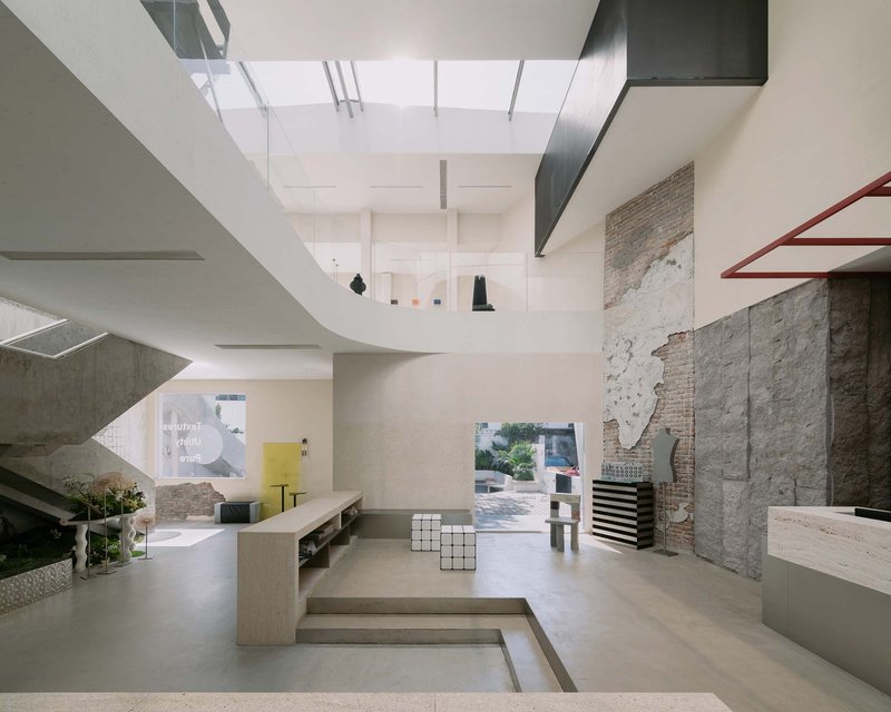 Double-height interior gallery with skylights, concrete stairs, exposed brick walls and mezzanine platforms