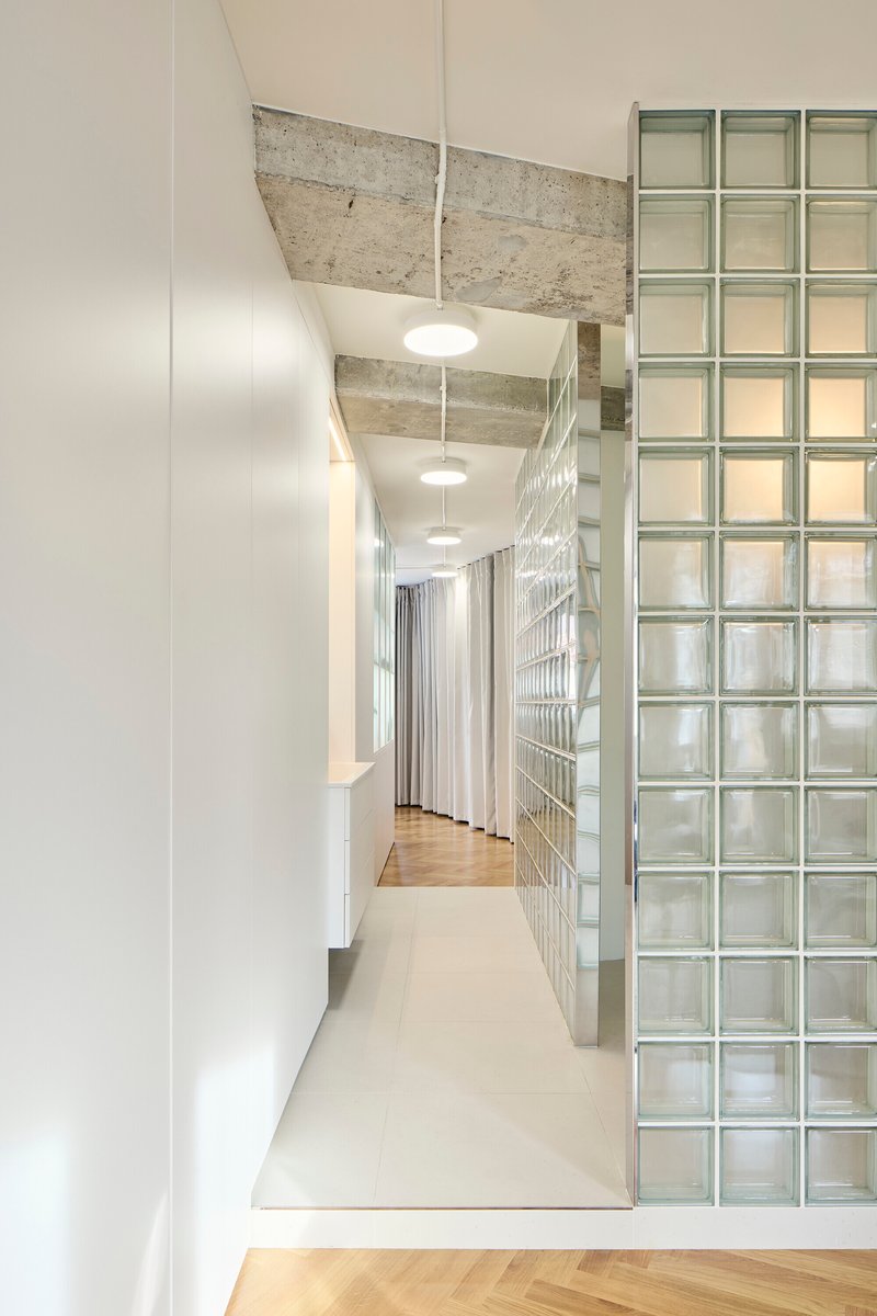 Corridor detail with glass block wall and view through to herringbone parquet flooring