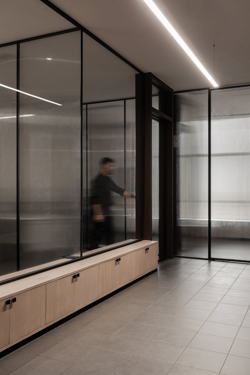 Corridor with translucent glass partitions and a person in motion captured with blur