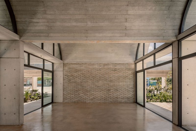 Interior room with vaulted concrete ceiling, polished concrete floor, and floor-to-ceiling glazed doors on both sides