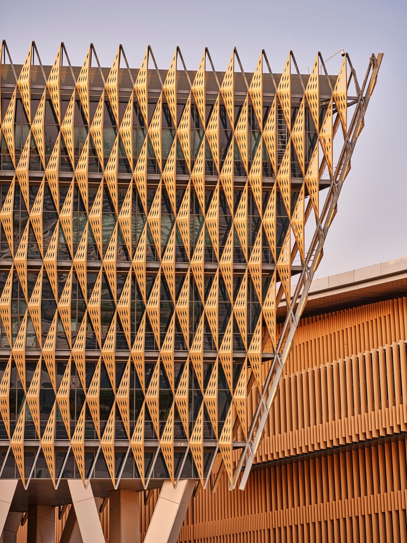 Close-up of the repeating timber brise-soleil with diamond module pattern in golden hour sun