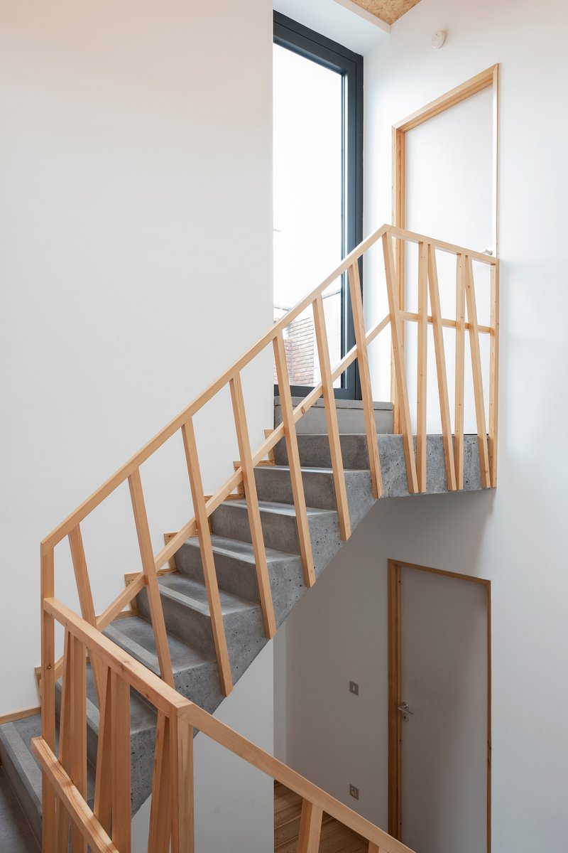 Steel and timber staircase with vertical wood balustrade leading to upper level skylight