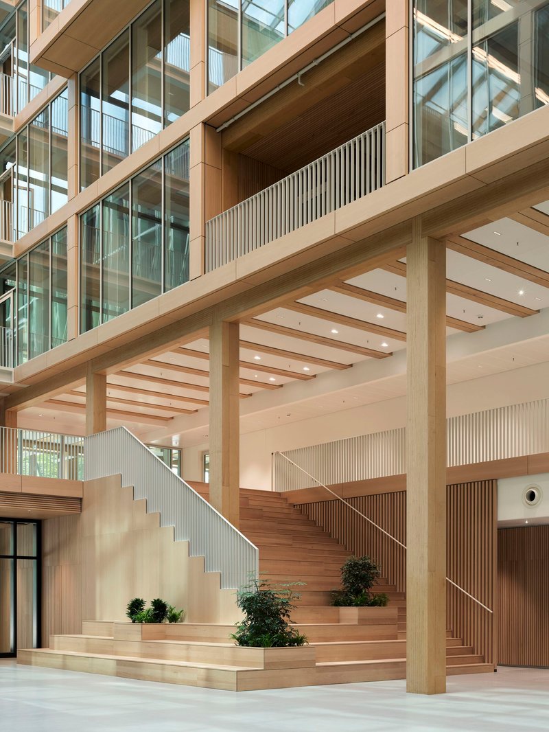 Multi-level timber staircase with exposed beams, glass railings, and potted plants on the landings