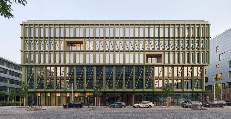 Street view of the layered facade with diagonal bracing and glass curtain wall under an overcast sky