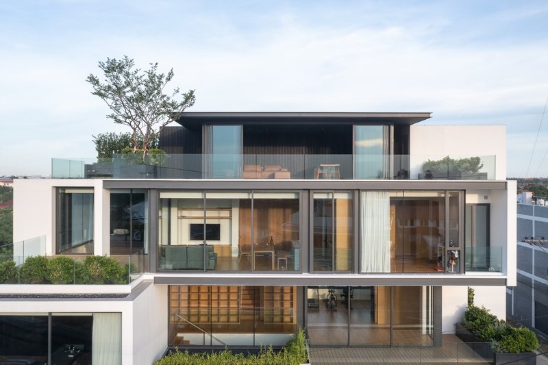 Layered facade showing floor-to-ceiling glass and dark horizontal banding at midday