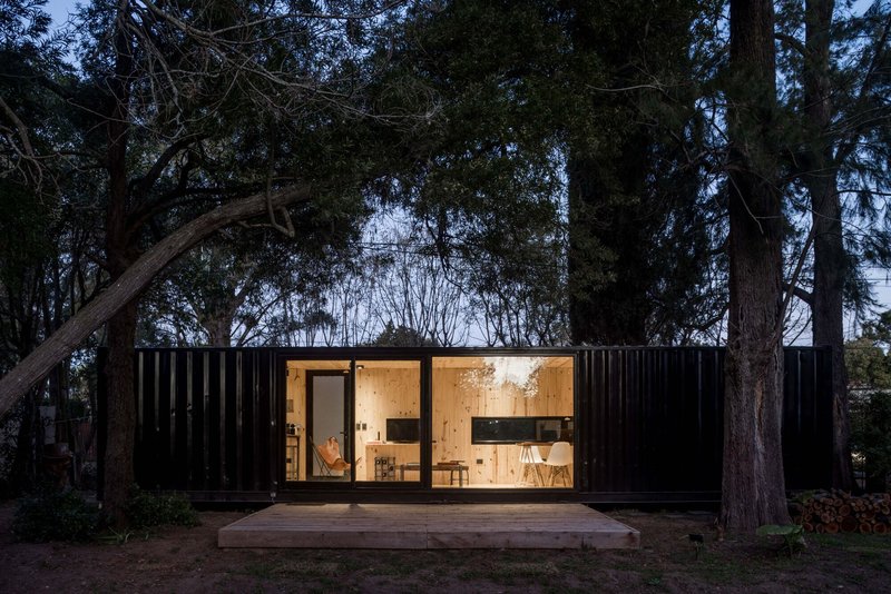 Front elevation showing the symmetrical black corrugated facade with central glazed opening