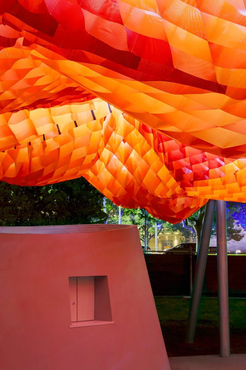 Close-up of the orange and red fabric waffle canopy suspended above a pink pavilion volume