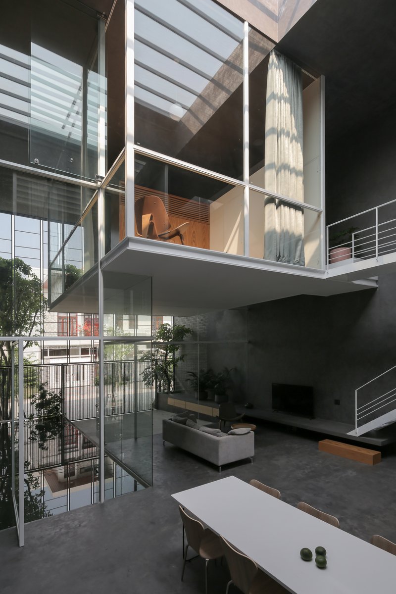 Interior view of cantilevered mezzanine with white steel frame overlooking the double-height living space below