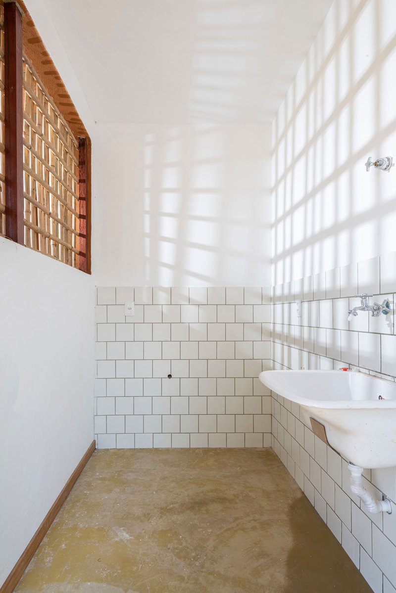 Bathroom with white subway tile wainscoting and bamboo lattice window casting gridded shadows