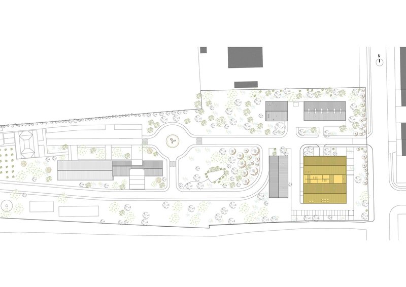 Site plan drawing showing the footprint highlighted in yellow among surrounding buildings and landscaping