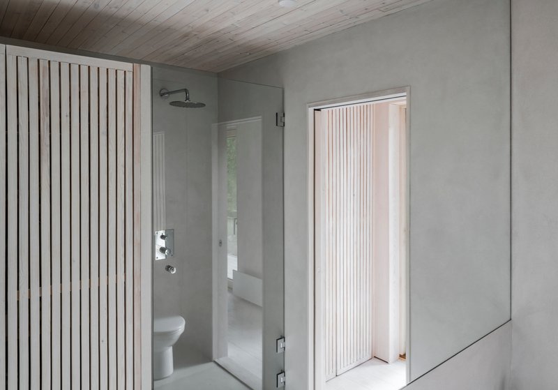 Bathroom with vertical timber slat screen, glass shower enclosure, and pale wood plank ceiling