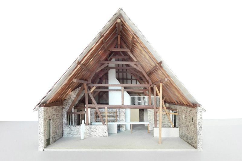 Section model showing exposed timber roof trusses and brick walls with interior mezzanine level